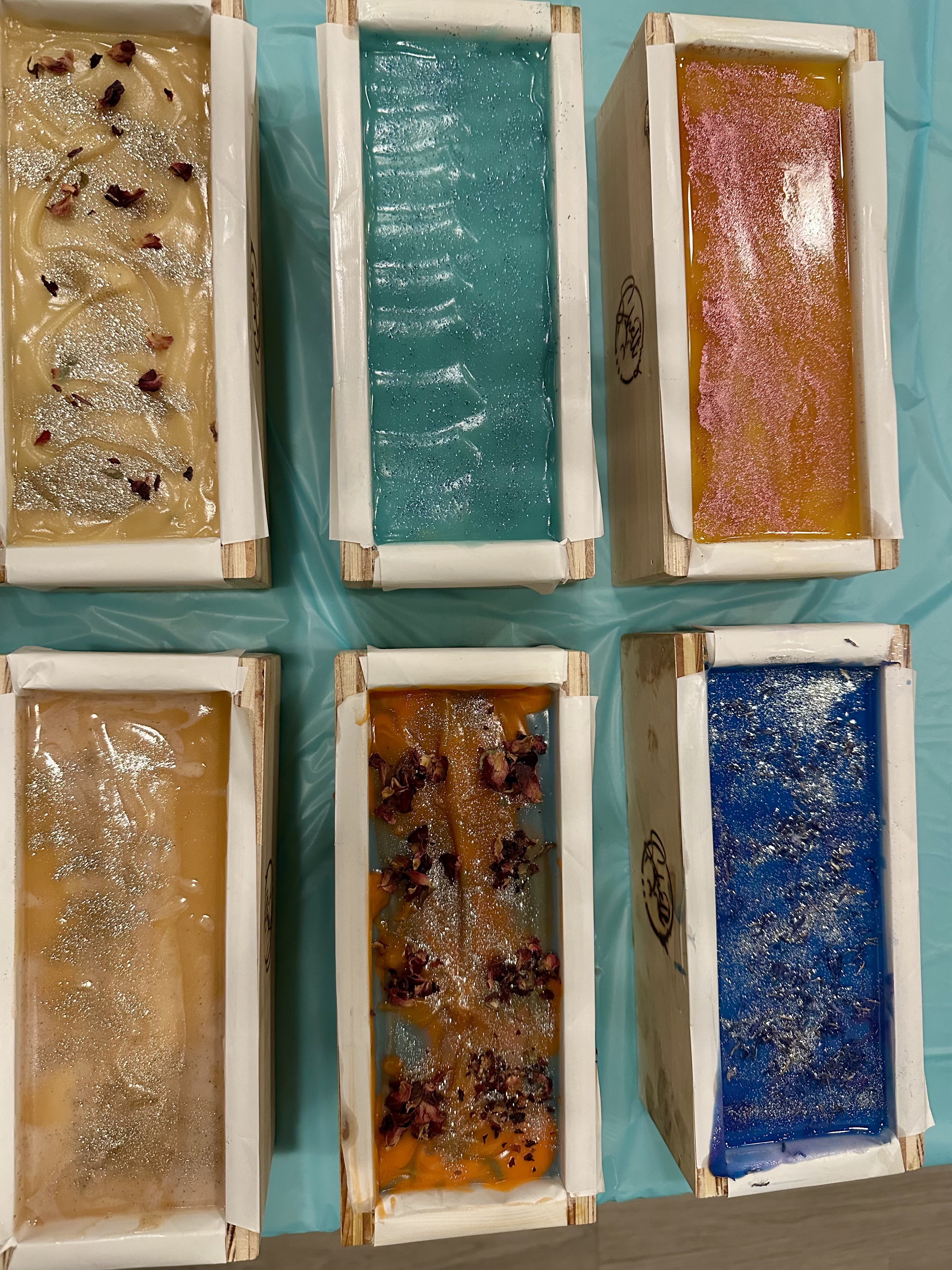 A rack of freshly poured soap loaves in every color